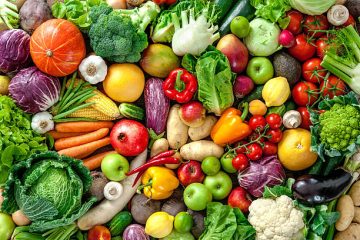Flat-lay berisi tujuh jenis buah segar—alpukat belah, blueberry, jeruk potong, pisang, apel merah, potongan nanas, dan kiwi—di atas permukaan terang, dengan teks judul ‘7 Buah Bernutrisi untuk Menjaga Kesehatan Tubuh’ di bagian tengah.